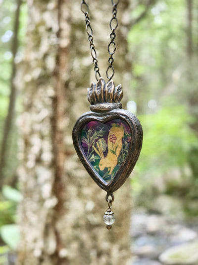 the hare is running races in her mirth; - sacred heart amulet